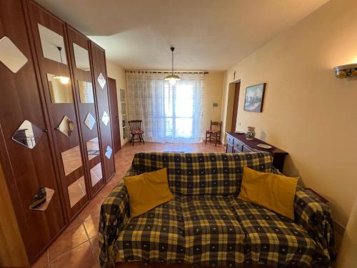 sala de estar con sofá y almohadas amarillas en Oasi Sicula Apartment, en Petrosino