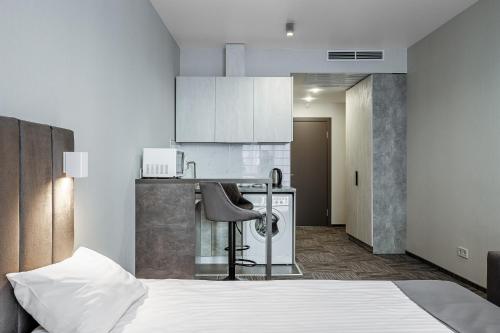 Cet appartement comprend une chambre avec un lit et une cuisine avec des placards blancs. dans l'établissement HAMSTER APART, à Kiev