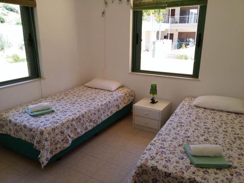2 camas en una habitación con 2 ventanas en Villa Erato, en Palaiokastro