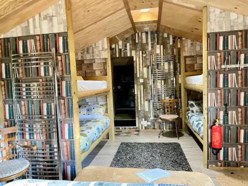 a room with four bunk beds with bookshelves at Strickland Arms in Great Strickland