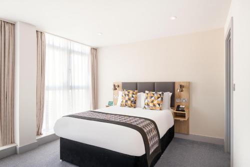 a bedroom with a large bed and a large window at Holiday Inn Birmingham City, an IHG Hotel in Birmingham