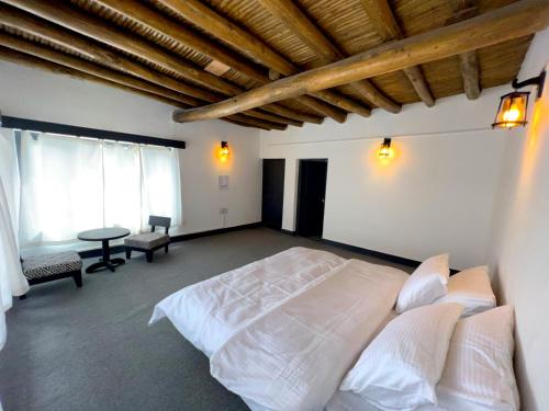 a bedroom with a white bed and a wooden ceiling at The Agartha House Ladakh in Leh