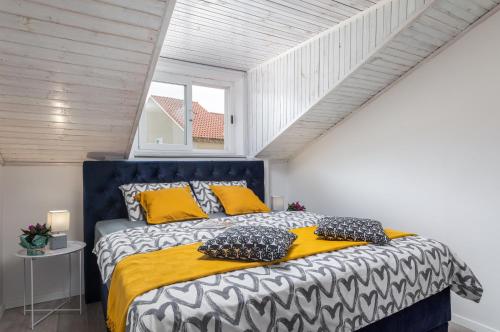 een slaapkamer met een groot bed met gele en zwarte kussens bij Apartment Tete Mare in Dubrovnik