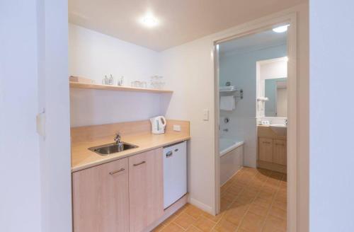 a small kitchen with a sink and a tub at Hope Harbour Hotel in Gold Coast
