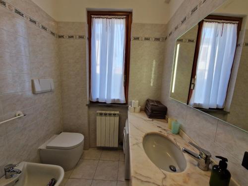a bathroom with a sink and a toilet and a mirror at Appartamento e Parco Sergiunca in Ameglia