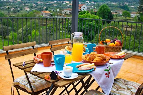 een tafel met ontbijtproducten en drankjes op een balkon bij Villa Rio in Torre de Cima