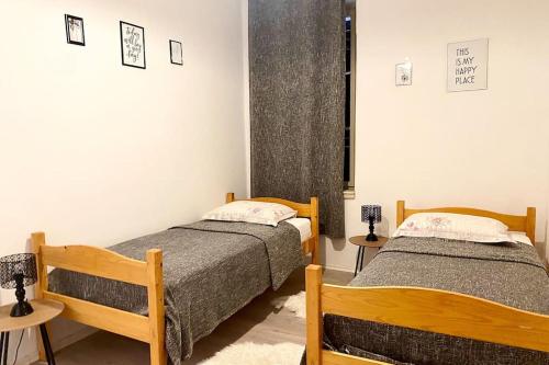twee bedden in een kleine kamer met twee tafels bij Apartment by the sea SONJA in Dugi Rat