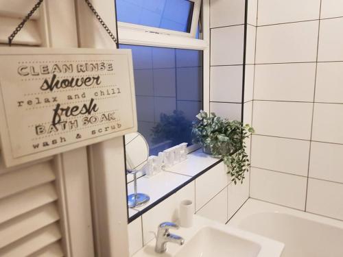 baño con lavabo, espejo y ventana en Bright 4-Bed house 15 min to Manchester Centre en Mánchester