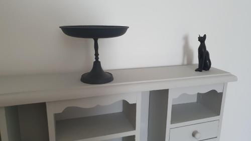a black cat sitting on top of a white table at La maison d`hôtes de Constance in Le Mans