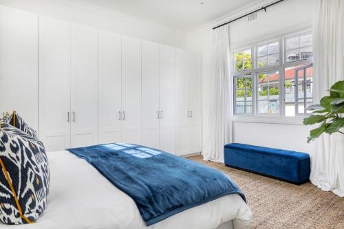 a white bedroom with a bed and a window at Secure & Central: Villa with Views of Table Mountain in Cape Town