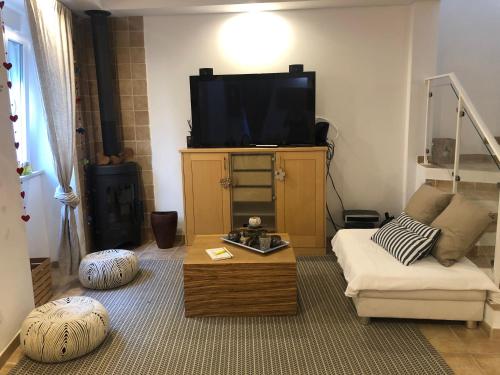 a living room with a couch and a flat screen tv at La petite maison in Portimão