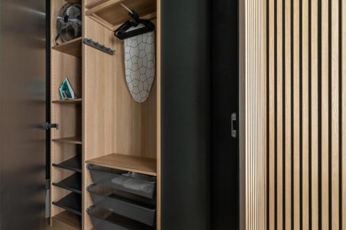 a walk in closet with wooden cabinets and wine bottles at Deluxe City Studio Kącik 10 by Renters in Krakow