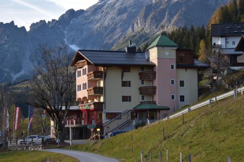 a building on the side of a hill with a mountain at Sonnhof am Hochkönig in Mühlbach am Hochkönig