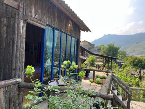 a house with glass doors and a wooden fence at H’nee House Ta Van in Sa Pa