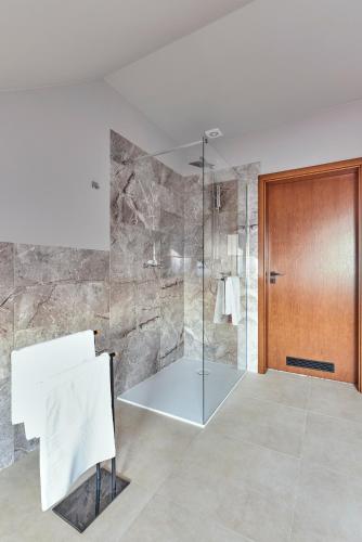 a bathroom with a shower with a glass door at Rodzinne Resorty Karkonosze in Wojcieszyce