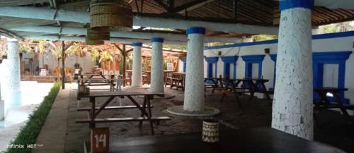 a patio with tables and chairs in a building at Lippo Carita Beach Utara Condo Noah in Carita