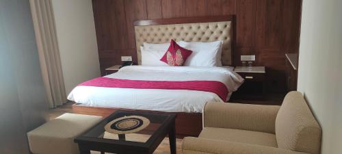 a hotel room with a bed and a chair at Vaydantaa - Luxury Boutique Resort Mussoorie in Mussoorie