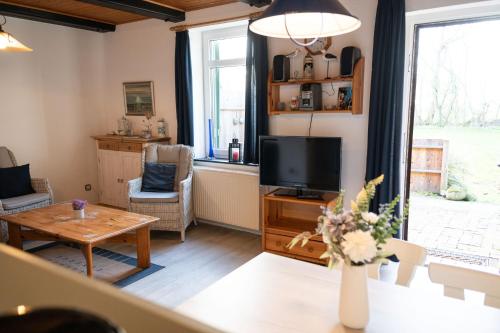 a living room with a television and a table at Sophienmühle I Nähe Carolinensiel in Wangerland