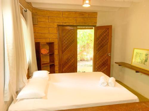 een slaapkamer met een bed met twee handdoeken erop bij Chalé Nova Terra in Imbassai