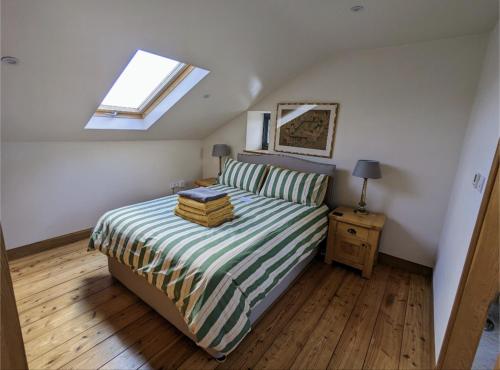 Un dormitorio con una cama con libros. en Treverrows Barn - Barn Conversion on the Farm en Penryn