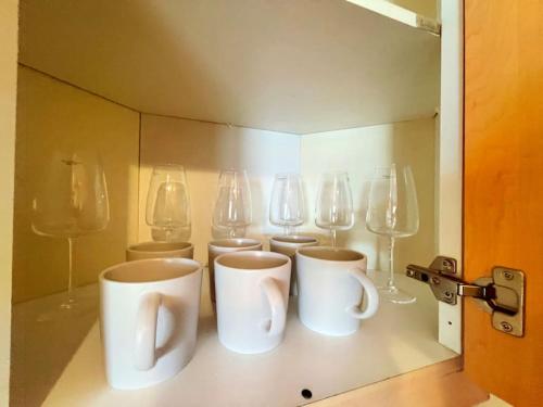 un groupe de tasses et de verres à vin sur un comptoir dans l'établissement Spacious 3-Bedroom Ground Floor Flat with Free Parking in Central Location, à Cardiff