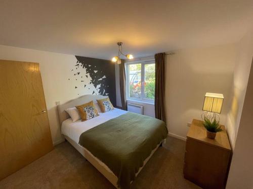 - une chambre avec un lit et une fenêtre dans l'établissement Spacious 3-Bedroom Ground Floor Flat with Free Parking in Central Location, à Cardiff