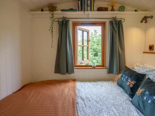 a bedroom with a bed and a window at Hurdlemakers Hut in Dorchester