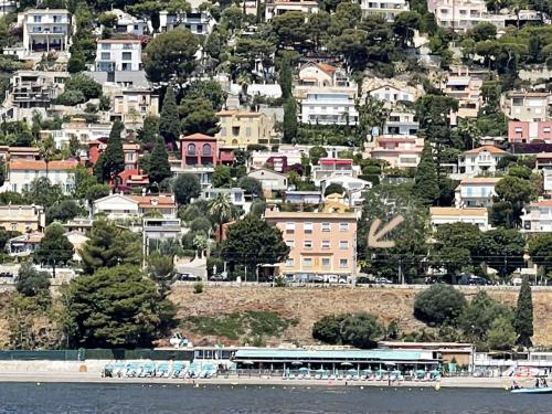 a city with houses and a boat in the water at Ezevacances Studio Capuccino vue mer 5 mn plage 7 mn gare Wifi in Èze