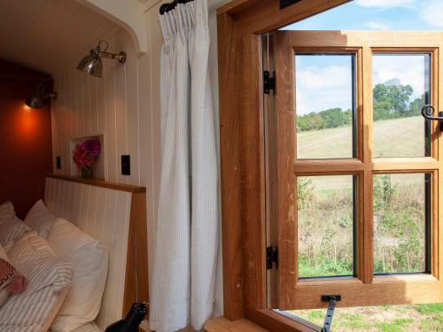 a room with a window and a couch in front at Spindleberry Hut in Dorchester