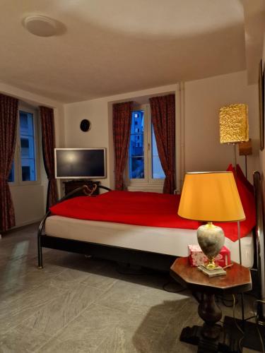 sypialnia z dużym łóżkiem i czerwonym kocem w obiekcie Bastis Luxury Studios - Free Parking w Lucernie