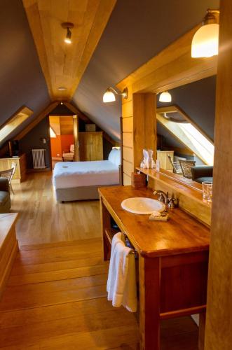 a bathroom with a sink and a bed in a room at Correntoso Lake & River Hotel in Villa La Angostura