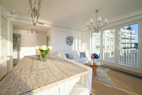 a living room with a table with flowers on it at Sunset Boulevard 1 apt 9 Bulwar Zachodzącego Słońca 1 w Marina Royale in Darlowko