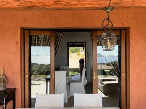 a dining room with white chairs and a dining table at Villa a Golfo Aranci con Vista su Tavolara in Marinella