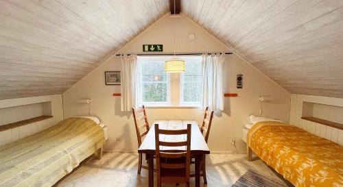a room with two beds and a table in a attic at STF Tivedstorp in Tivedstorp