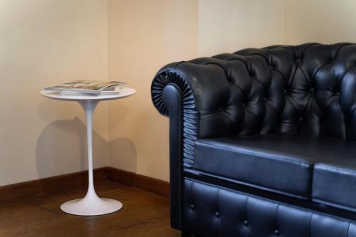 a black leather couch sitting next to a small table at Boccioleto Resort - Place of Charme in Montaione