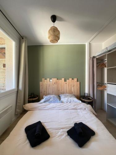 - une chambre avec un grand lit et 2 serviettes noires dans l'établissement Studio - 19, à Rochefort-en-Terre