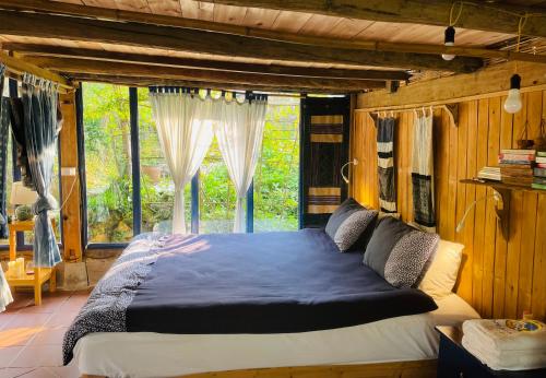 a bedroom with a large bed in front of a window at H’nee House Ta Van in Sa Pa