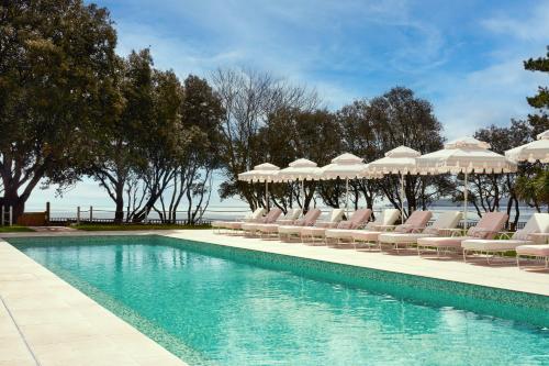 a swimming pool with lounge chairs and umbrellas at The Nici in Bournemouth