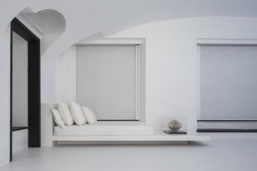 a white room with a bench with two pillows at Hotel Palazzo Durazzo Suites in Genova