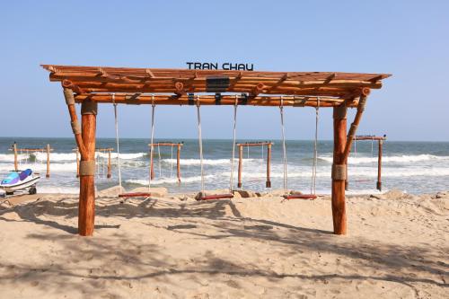 a wooden shelter on a beach with the ocean at Trân Châu Beach & Resort in Ba Ria