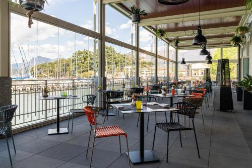 a restaurant with tables and chairs and a large window at Araba Fenice Hotel in Iseo