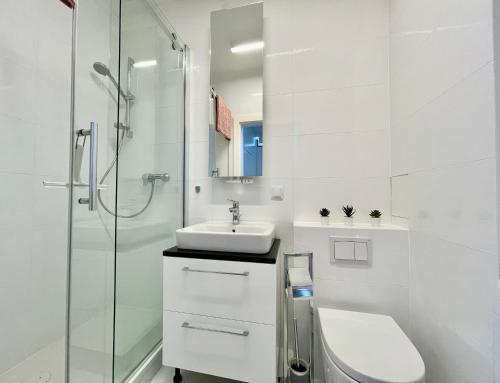 a bathroom with a toilet and a sink and a shower at Elegant Apart-800m Main Square-Parking and lift in Wrocław