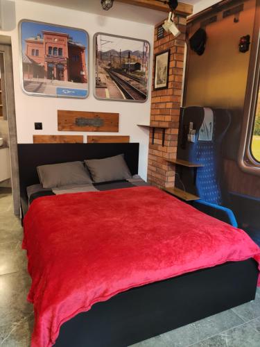 um quarto com uma cama vermelha num vagão de comboio em Noclegi pod Wiaduktem em Wałbrzych