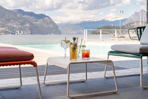 a table and chairs with a view of the water at Araba Fenice Hotel in Iseo