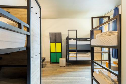 a dorm room with bunk beds and a hallway at a&o Dortmund Hauptbahnhof in Dortmund
