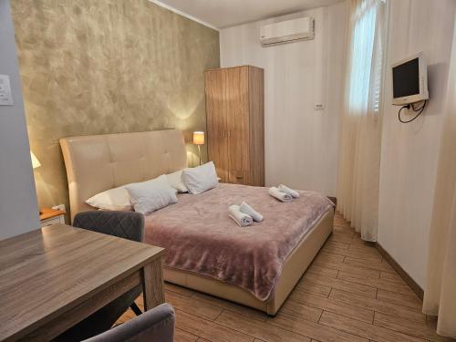 a bedroom with a bed with two towels on it at Heritage Stone Wall Room & Apartment in Split