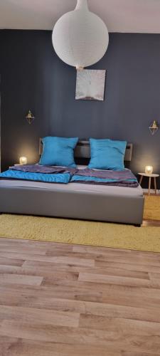 a bed with blue pillows and a blue wall at Ferienwohnung Marktblick Goslar in Goslar