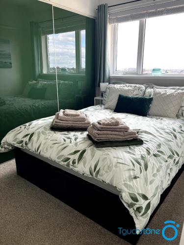 a bed with towels on it in a bedroom at Cosy Home with links to Bham, Solihull, NEC, M42 in Sheldon