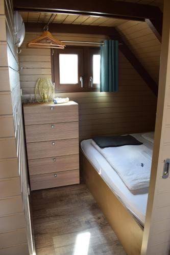 a small bedroom with a bed and a dresser at Chalet im See- Nr 44 in Rust