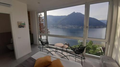 1 dormitorio con ventana grande con vistas a la montaña en Top Lake View, en Faggeto Lario 